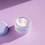 Cosmetic jar with face cream on a purple background