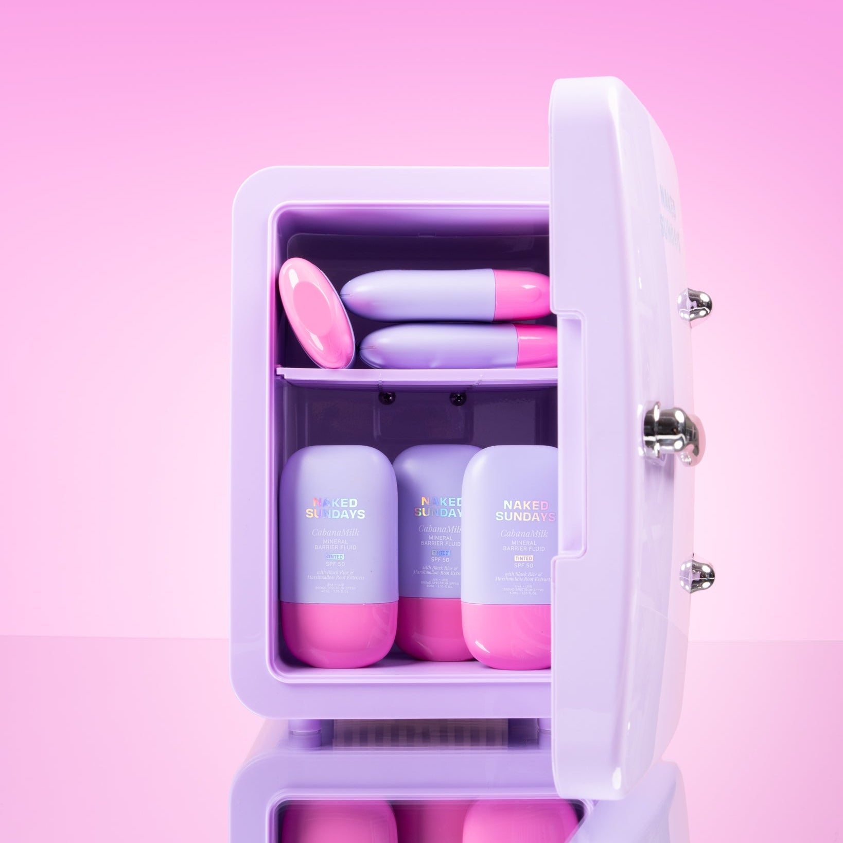 Lilac cosmetics fridge with pink and lilac CabanaMilk SPF50 products on a pink background