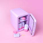 Lilac cosmetics fridge with pink and lilac Cabanamilk SPF50 bottles on a pink background