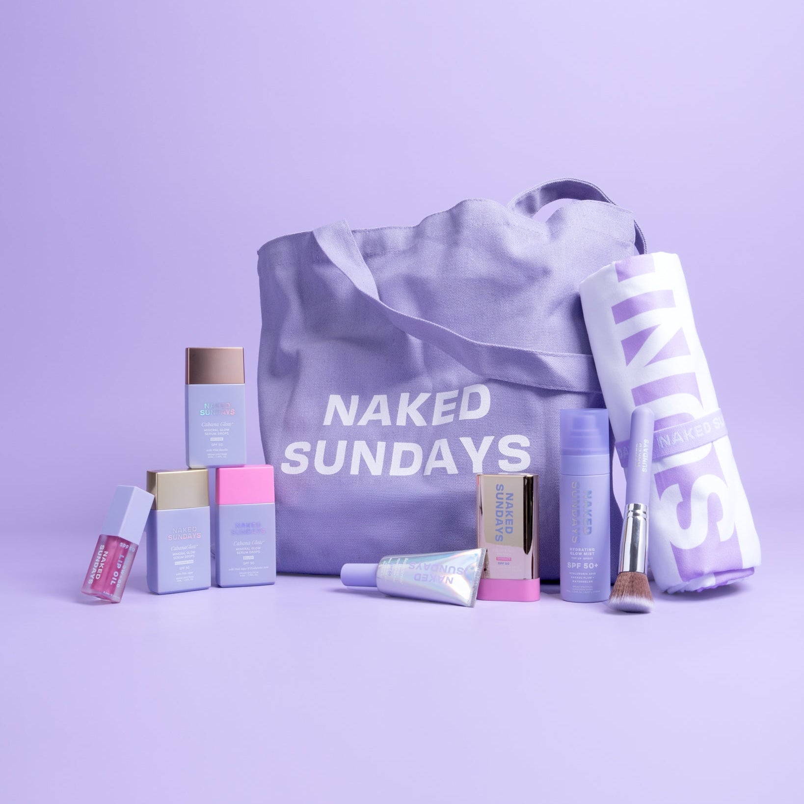 Collection of beauty products and a tote bag with 'Naked Sundays' branding on a purple background