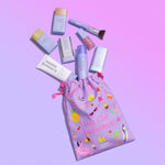 Collection of Naked Sundays products including a 'Hot Girl Sunscreen' bag on a pink background