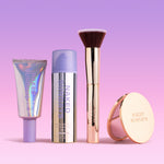 SPF Makeup products including BeautyScreen, CabanaClear in Illuminating, a gold compact mirror, and a gold brush with 'Naked Sundays' branding on a gradient pink and purple background.