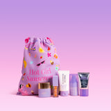 Naked Sundays drawstring bag set with mini Cabana Glow serum drops, Glow + Go Lip Oil in Salted Caramel, Mini Body Sunscreen Creme, Travel Hydrating Glow Mist and Mini Cabana Clear Water Gel Serum.