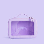 A purple travel cosmetic case made of vegan leather, with a clear window showing the brand name 'Naked Sundays' on the front.