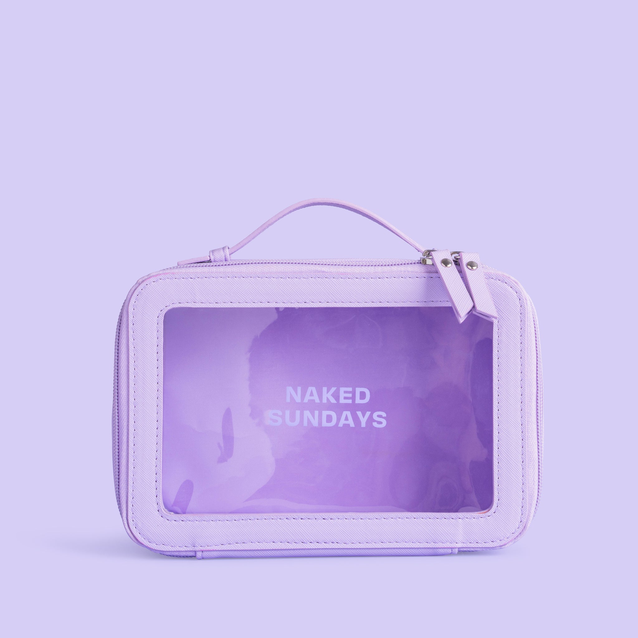 A purple travel cosmetic case made of vegan leather, with a clear window showing the brand name 'Naked Sundays' on the front.